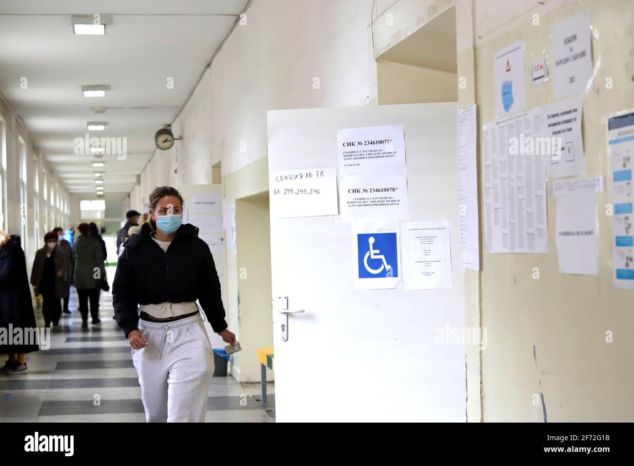 Le persone con maschere votano durante la pandemia di coronavirus per il bulgaro elezioni parlamentari e per la prima volta nella storia con carta e macchin Foto Stock