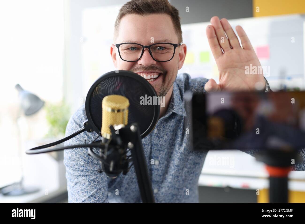 L'uomo sorridente alzò la mano in gratitudine e scrive video al blog Foto Stock