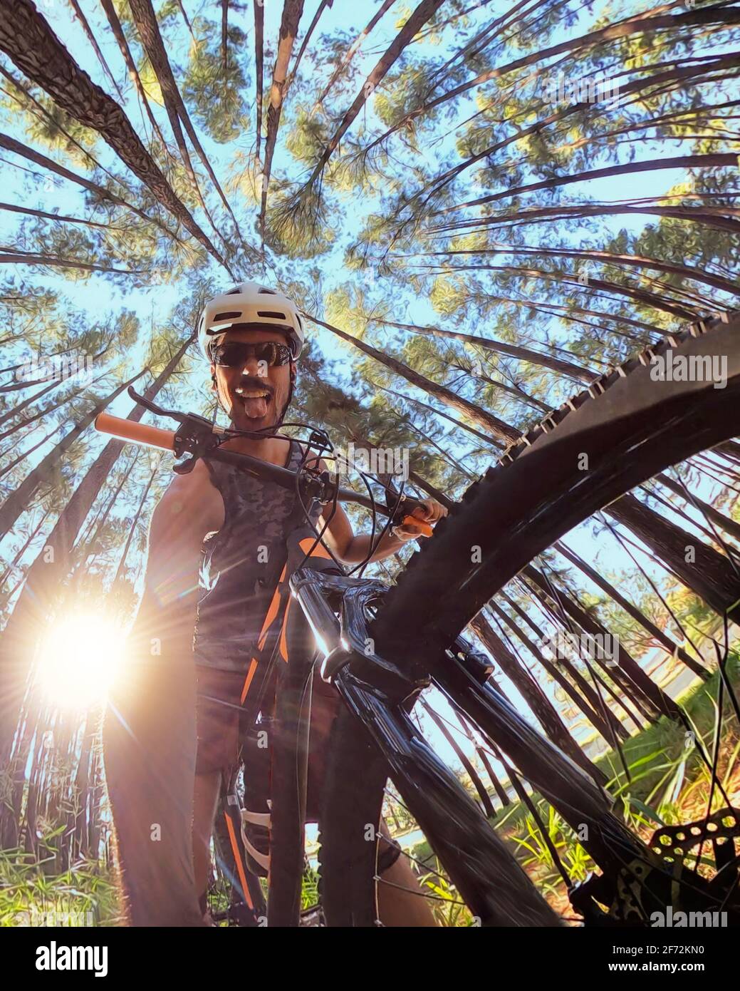 Ciclista nera sul sentiero forestale prendendo un selfie in bicicletta il giorno di sole Foto Stock