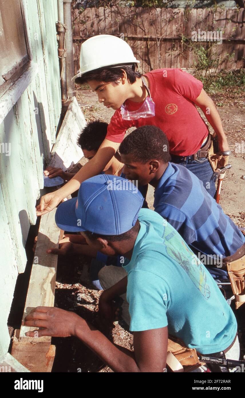 Austin TX USA: I volontari di classe di carpenteria ispanica e nera della scuola superiore fanno le riparazioni sulla casa di un uomo anziano. ©Bob Daemmrich Foto Stock