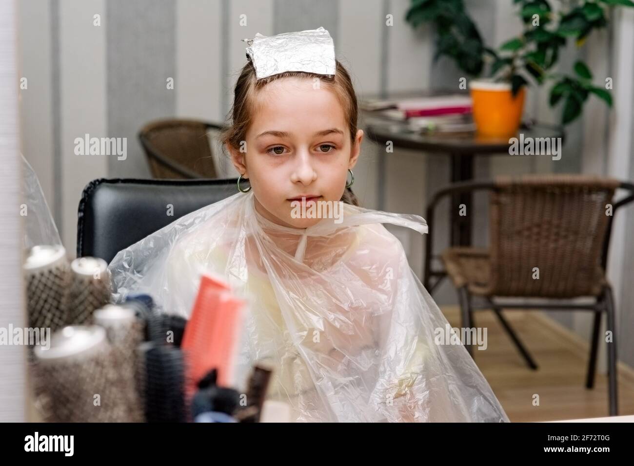 Il parrucchiere tinge i capelli della ragazza nel salone di bellezza. Moda tinteggiato bangs. Capelli sbiancati Foto Stock