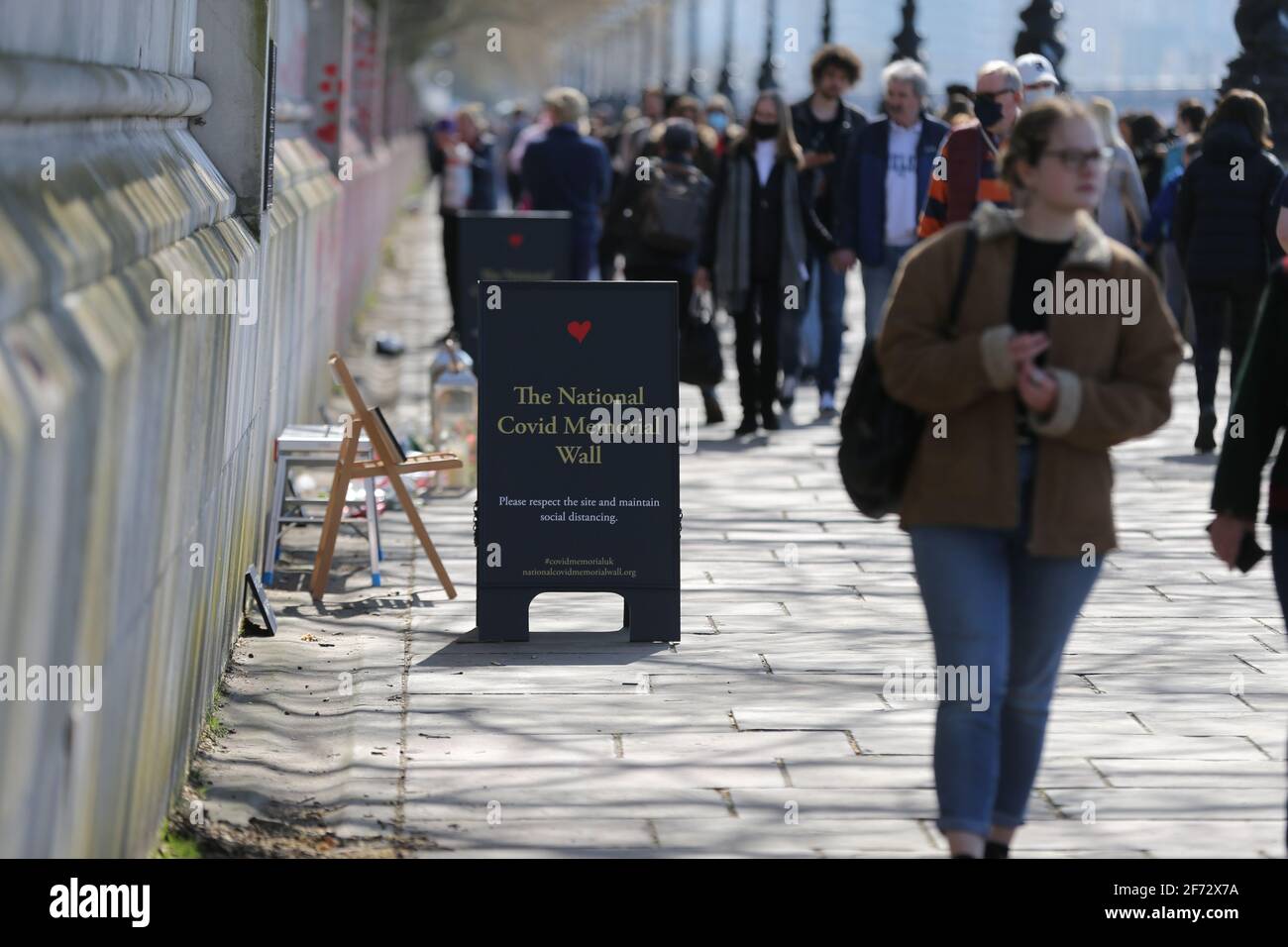 Londra, Inghilterra, Regno Unito. 4 Apr 2021. La gente passa davanti al National Covid Memorial Wall sul Tamigi a Londra. Ogni cuore è destinato a simboleggiare un individuo morto a causa della pandemia di Coronavirus nel Regno Unito. Gli organizzatori puntano ad avere 150 mila cuori sul muro che si trova di fronte alle Camere del Parlamento. Credit: Tayfun Salci/ZUMA Wire/Alamy Live News Foto Stock