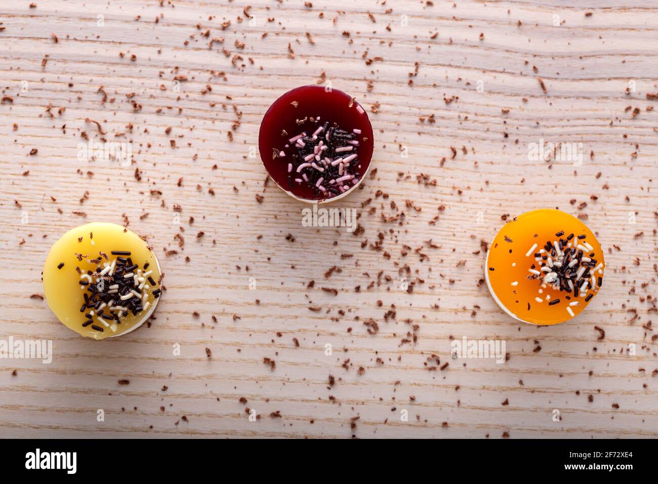 Tre mini bavarois con frutta su tavolo di legno - piano visualizza Foto Stock