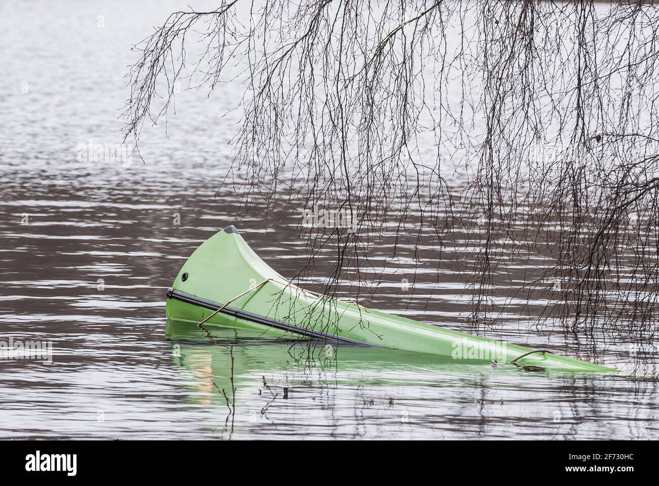 Canoa allagata verde che giace nel lago Foto Stock