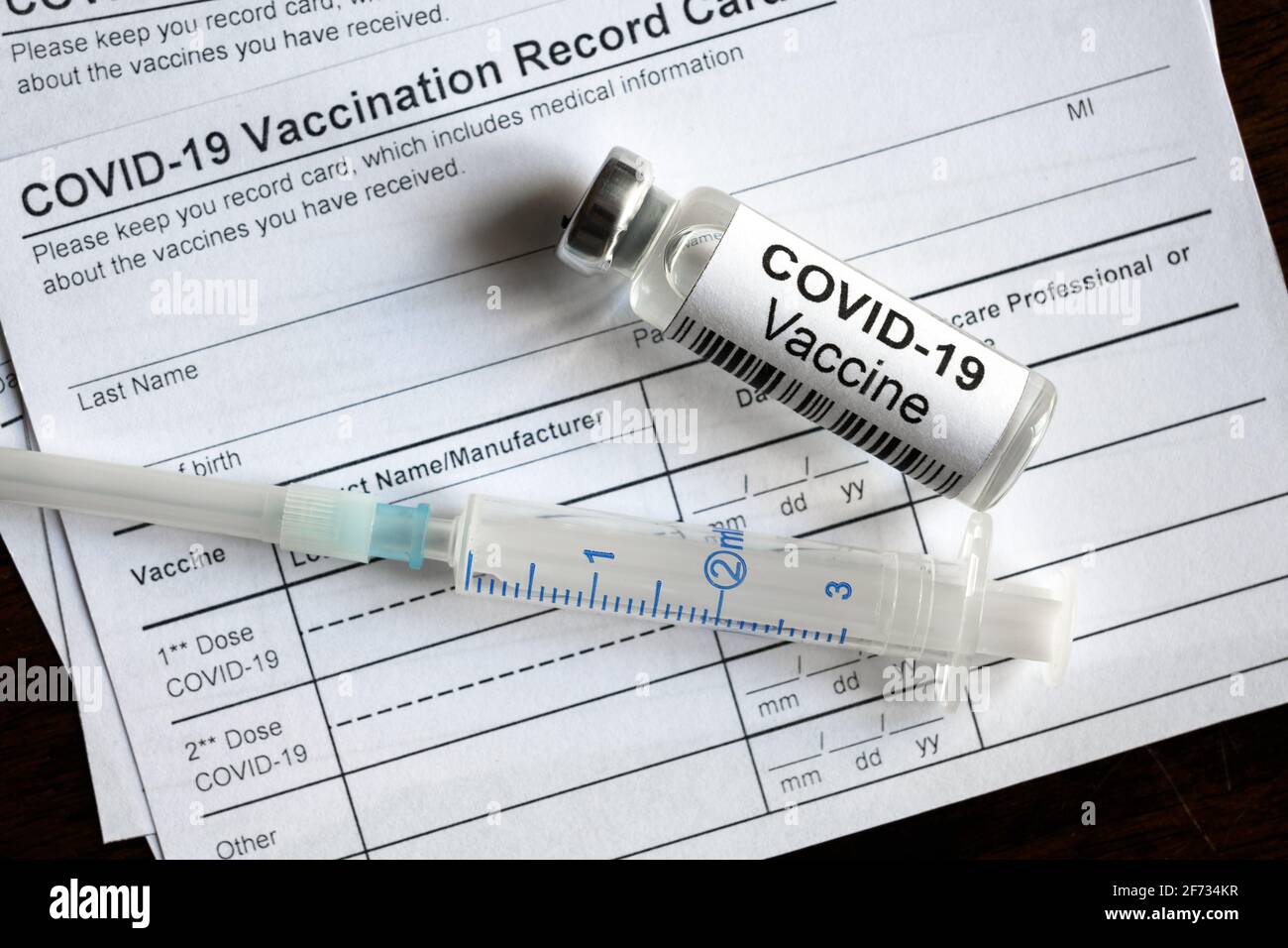 Il flacone e la siringa del vaccino COVID-19 sono riportati sulla scheda di registrazione della vaccinazione con coronavirus, necessaria una forma medica per il viaggio. Concetto di certificato di immunizzazione, Foto Stock