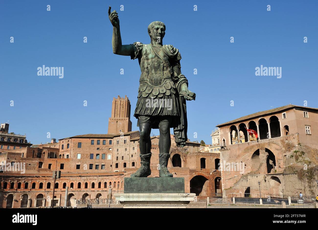 Italia, Roma, statua in bronzo del romano imperatore Traiano e mercati di Traiano Foto Stock