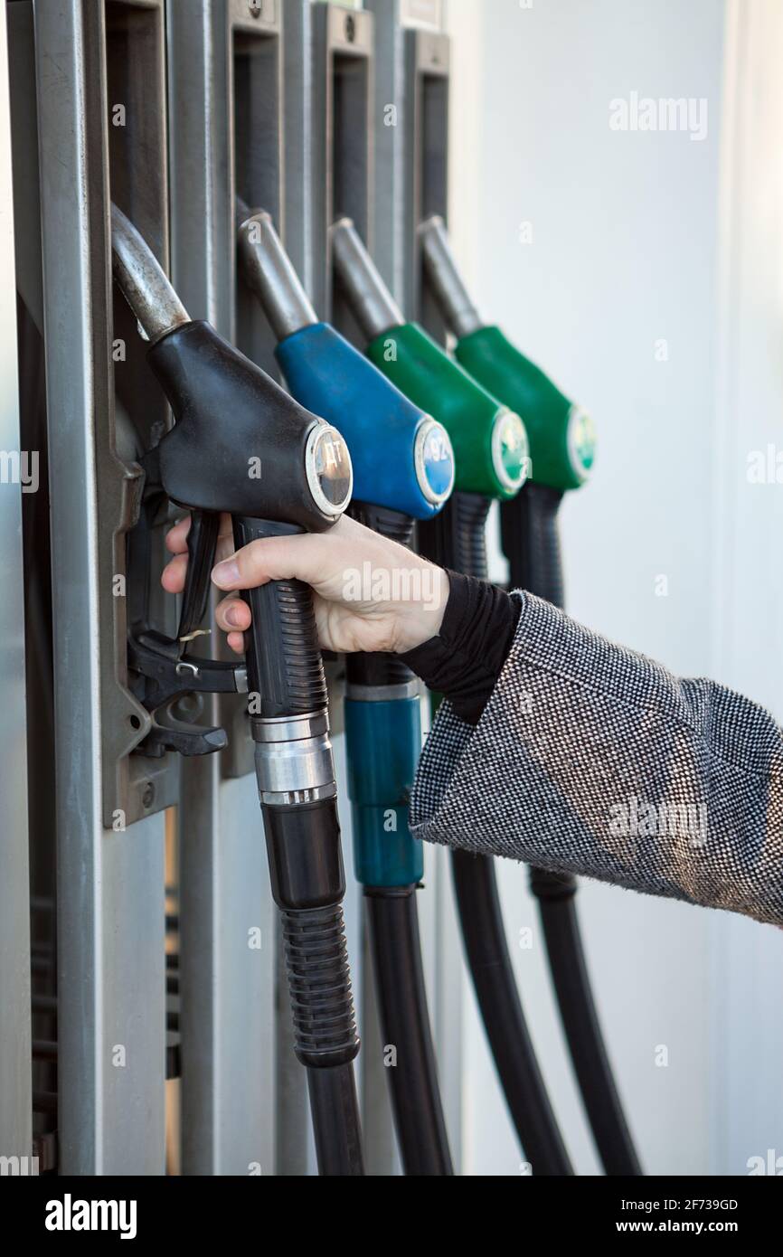 Ugello di rifornimento manuale femmina caucasico con diesel sulla stazione di servizio, vista ravvicinata Foto Stock
