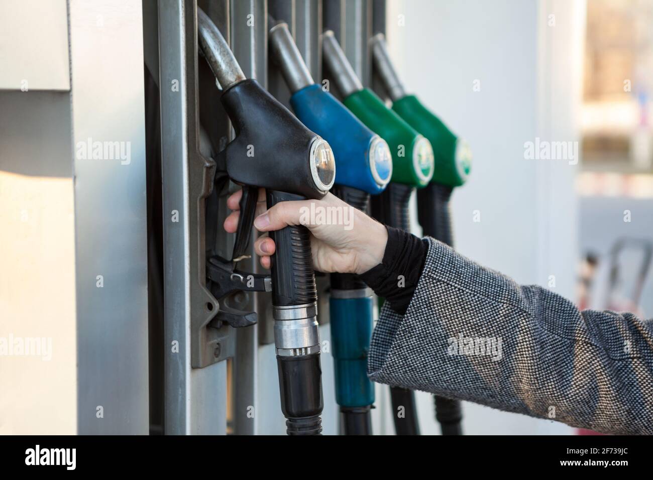 Ugello di rifornimento con guida a mano umana con diesel sulla stazione di servizio, vista ravvicinata Foto Stock