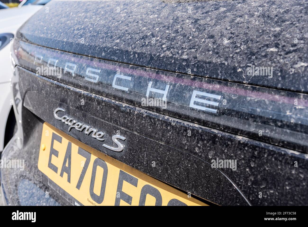 Porsche Cayenne S auto con uno strato di polvere di sabbia del deserto del Sahara dopo la pioggia presso la concessionaria a Colchester, Essex, Regno Unito. Le tempeste di sabbia soffiarono polvere nel Regno Unito. 2020 auto Foto Stock