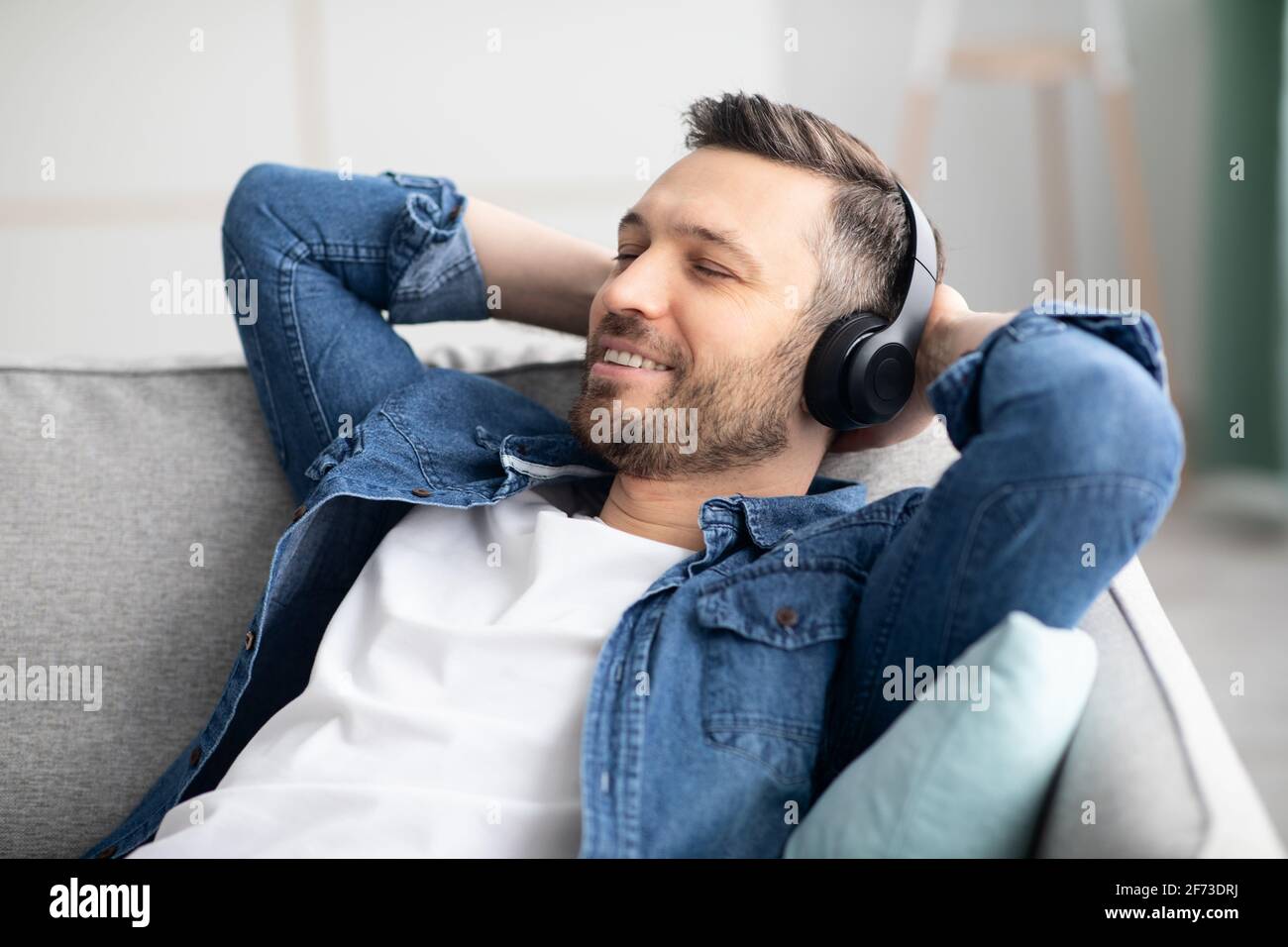 Gioioso uomo di mezza età in cuffia che ascolta la musica Foto Stock