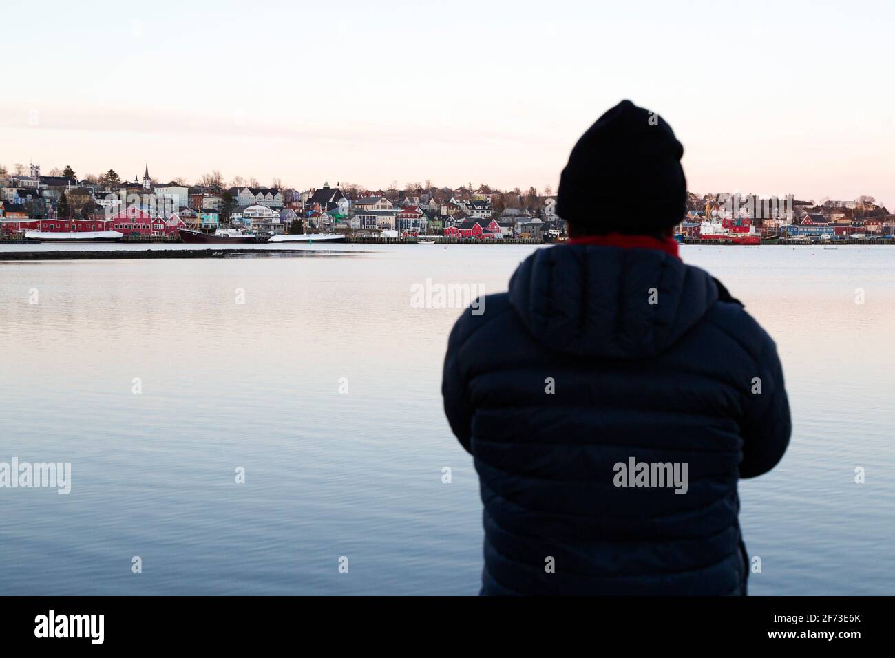 Una persona guarda verso il lungomare nella città di Lunenburg, Nuova Scozia, Canada. Lunenburg è costruita secondo una struttura coloniale ed è un mondo UNESCO Foto Stock