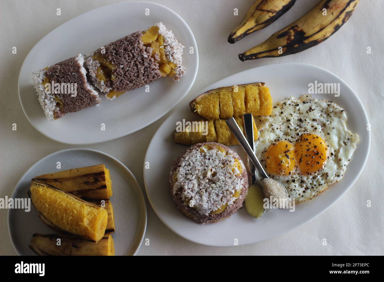 Torta di farina di miglio al vapore con un generoso strato di cocco fresco nel mezzo. Localmente conosciuto come Ragi puttu. Servita con padella al vapore e patatine fritte Foto Stock