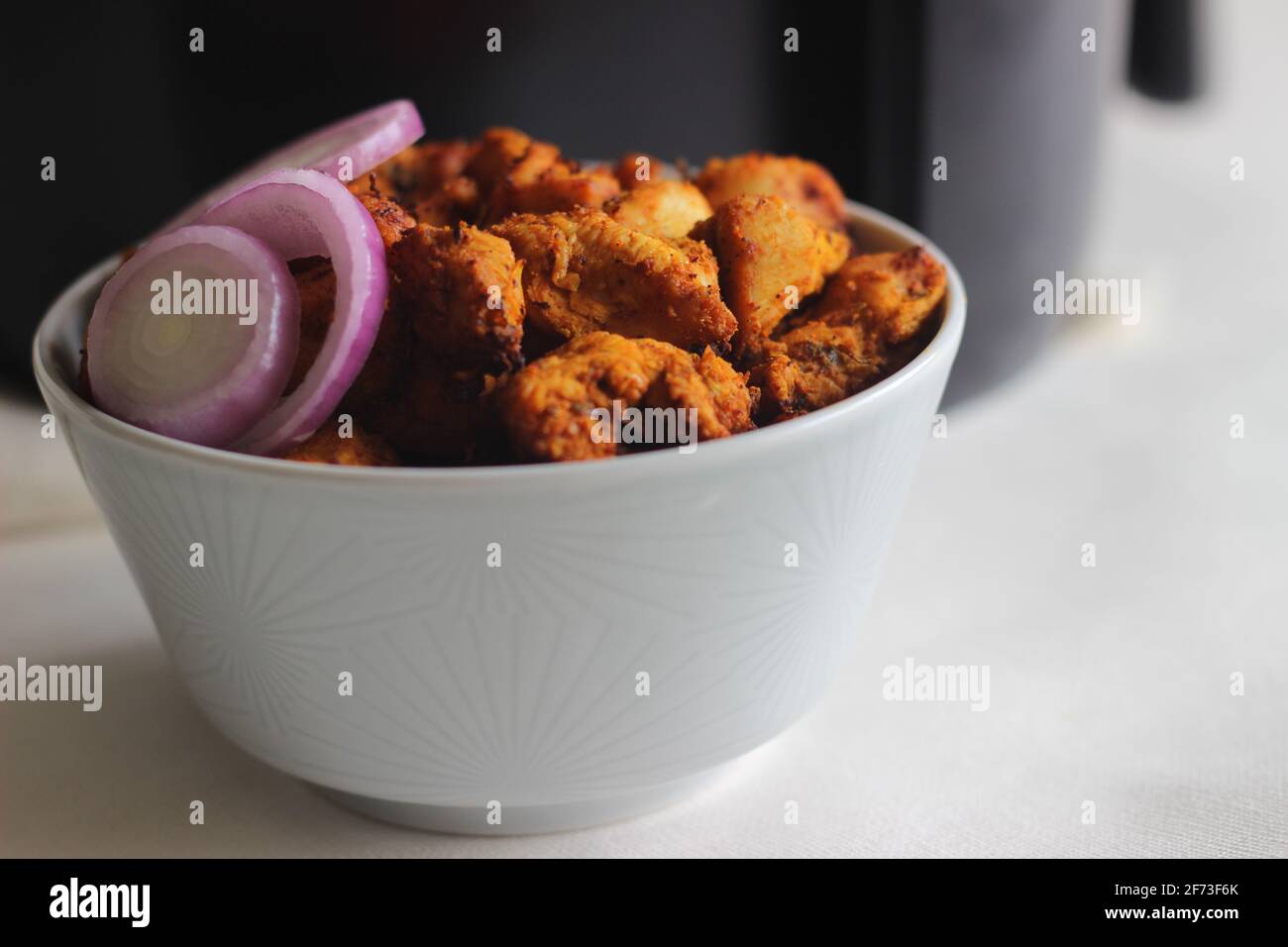 Bocconcini di pollo marinati e fritti d'aria. Scatto su sfondo bianco Foto Stock