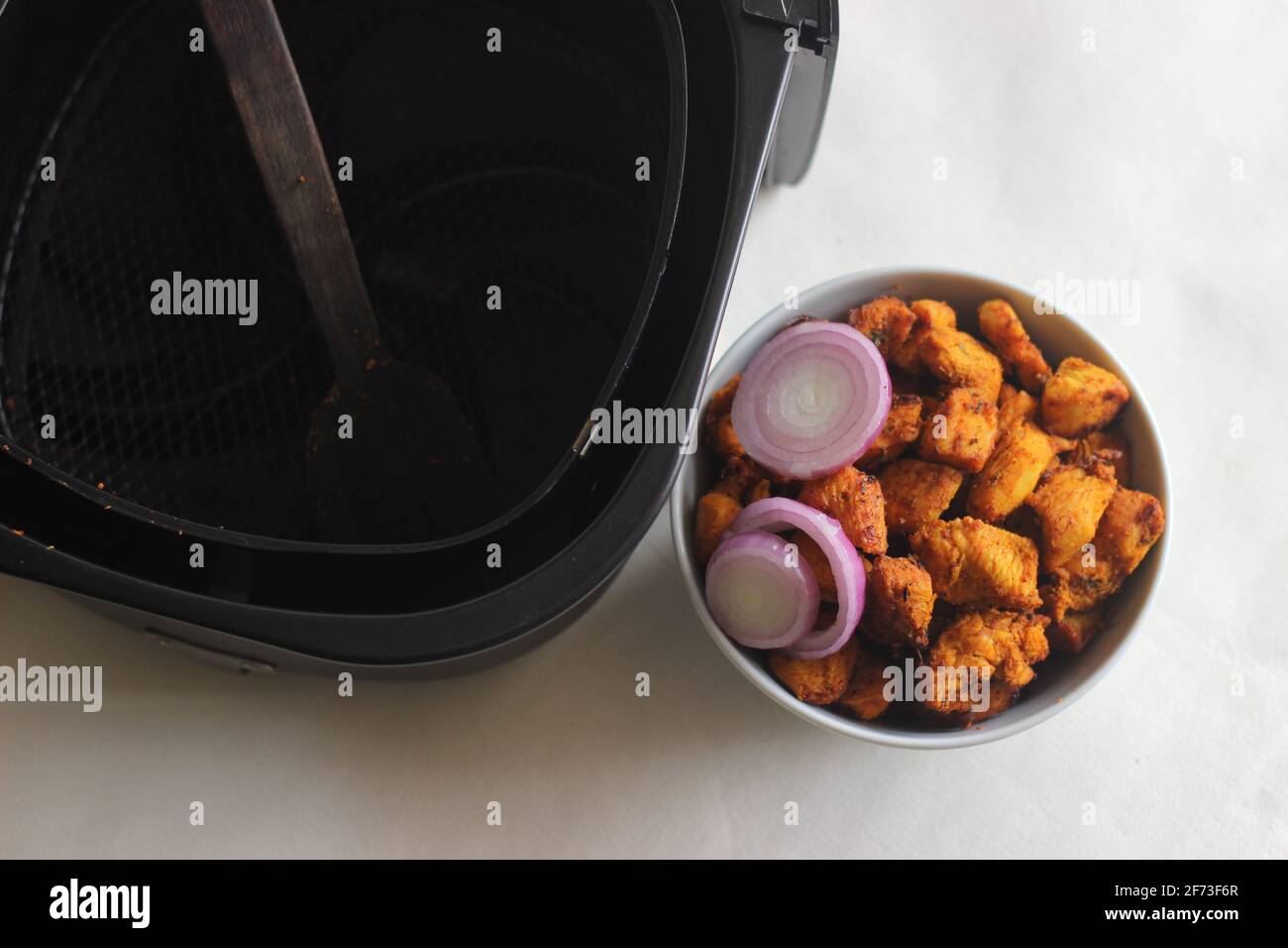 Bocconcini di pollo marinati e fritti d'aria. Scatto su sfondo bianco Foto Stock