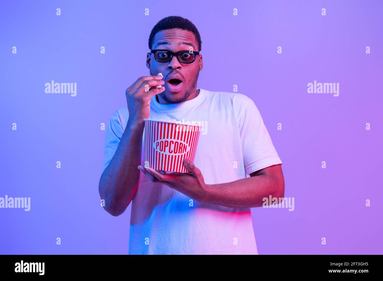 Ritratto di guy afro-americano scioccato in 3D occhiali mangiare Popcorn Foto Stock