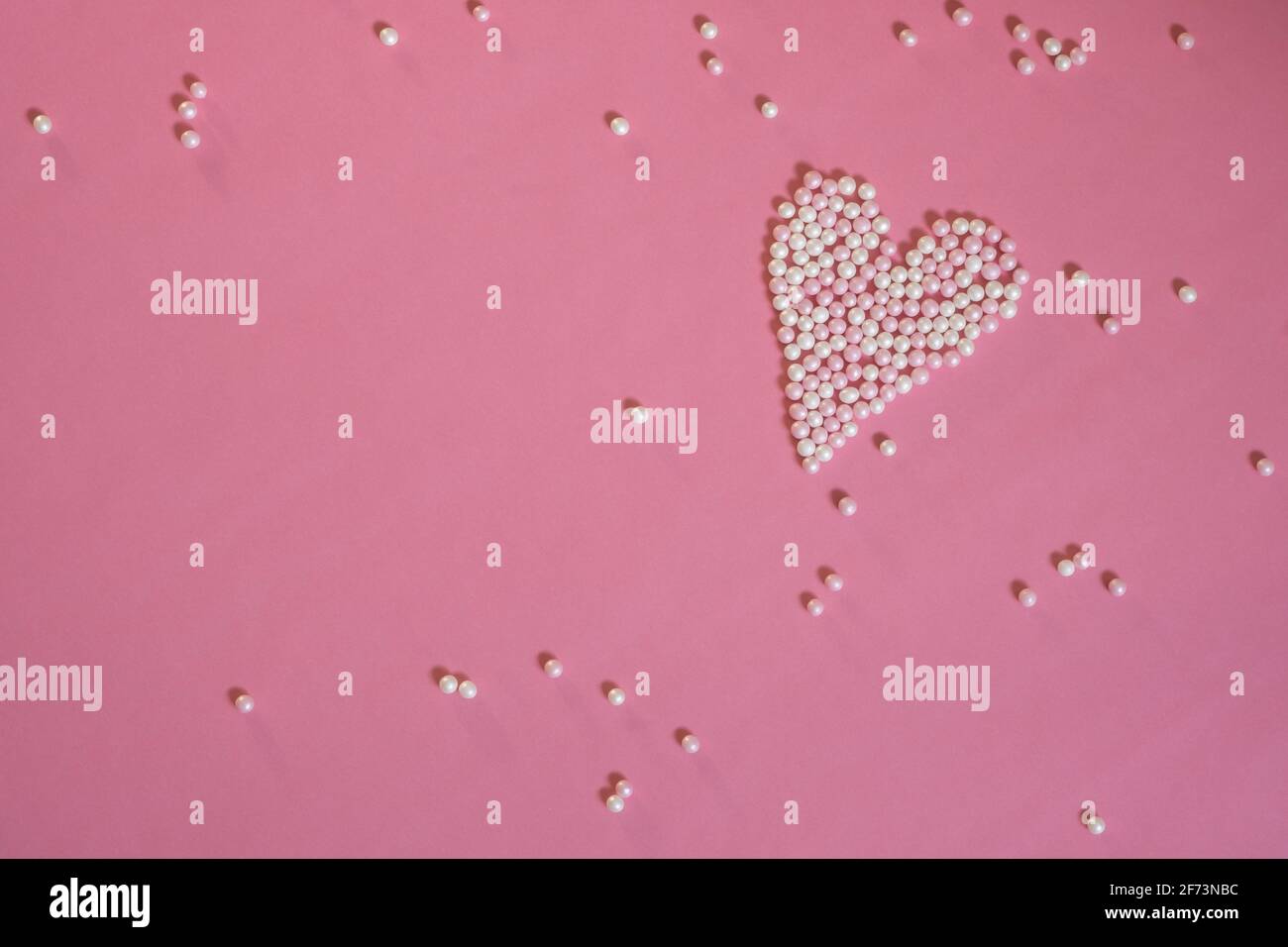 Cuori piccoli fatti di perle su sfondo rosa. Saluti per la Festa della mamma. Auguri d'amore per San Valentino. Spazio per il testo. Foto Stock