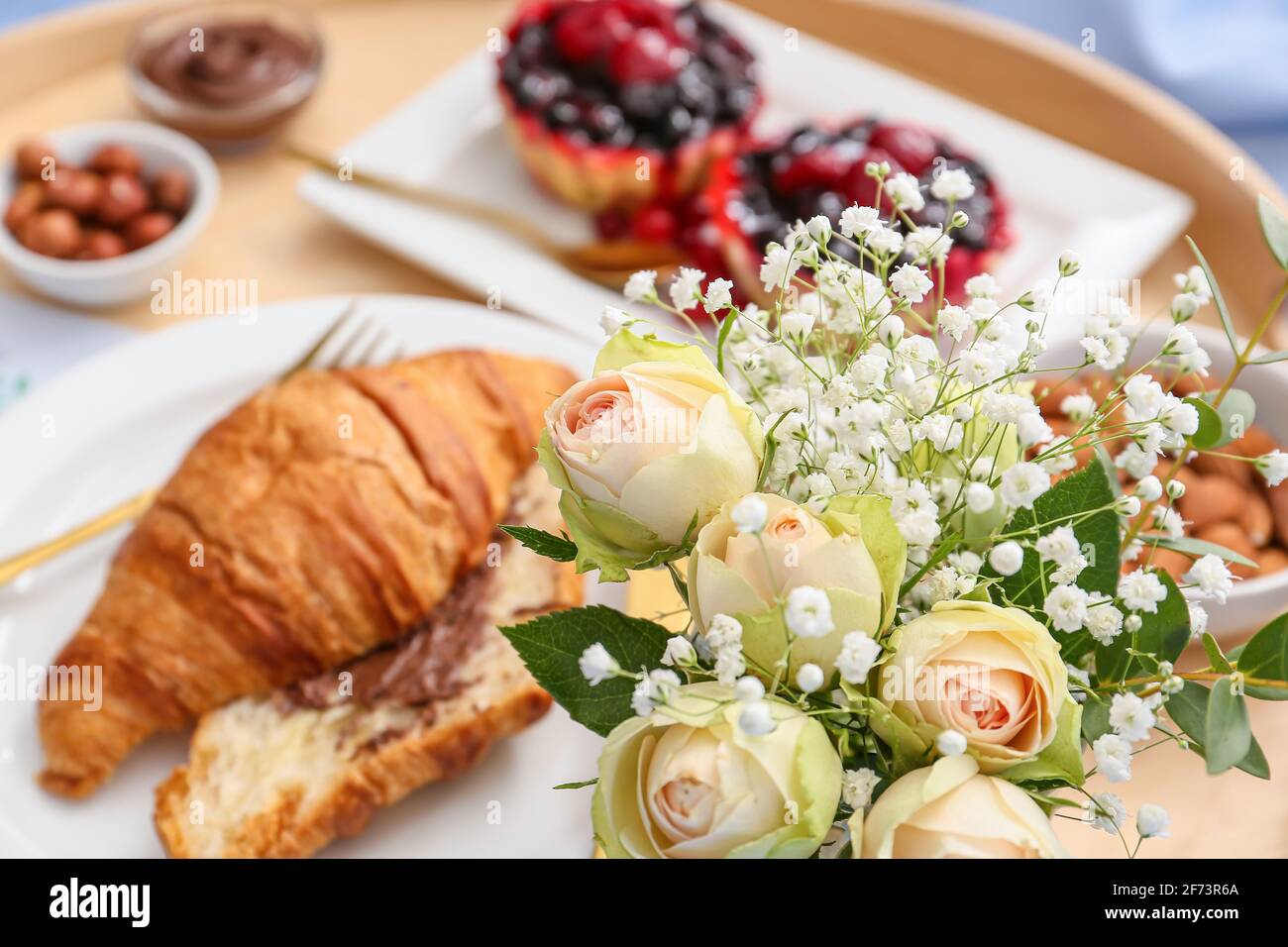 Bel bouquet di fiori con gustosa colazione, guardaroba Foto Stock