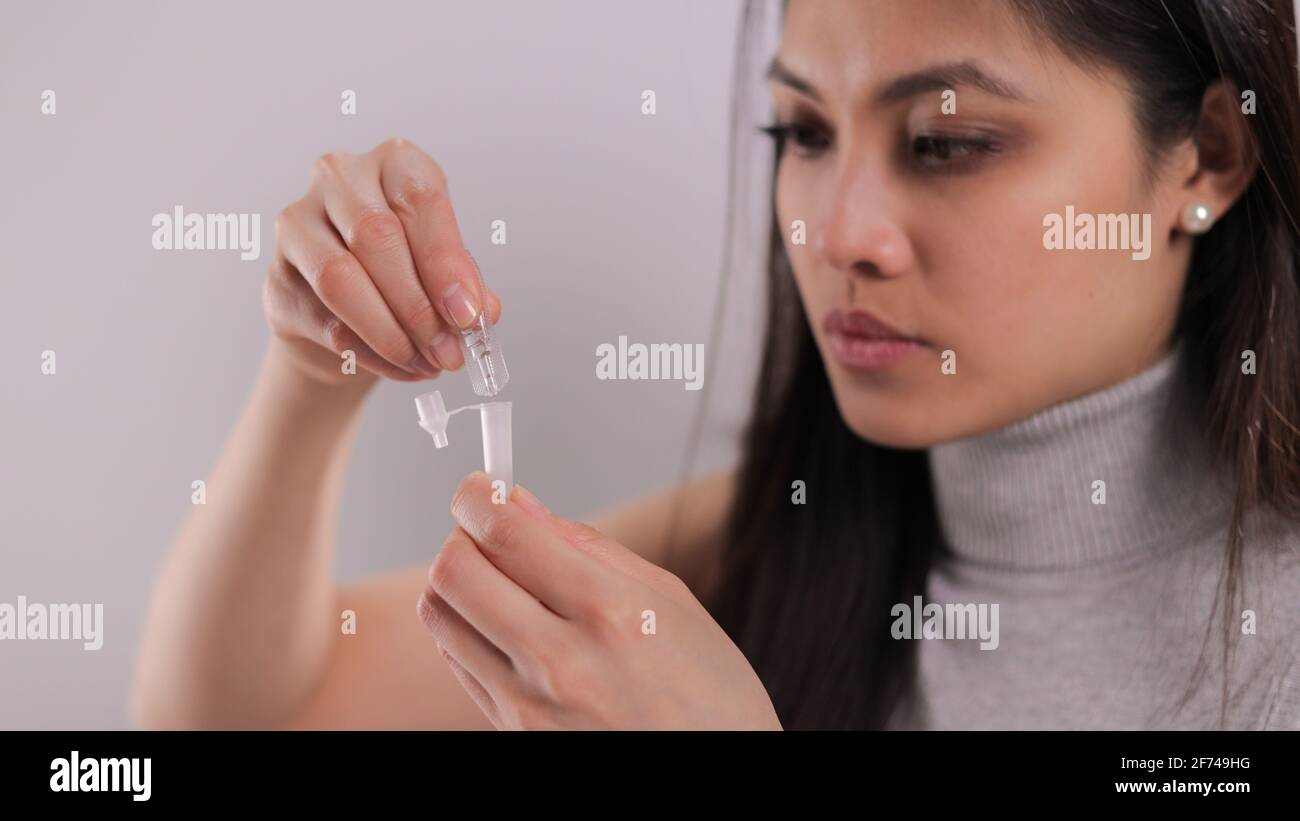 Giovane donna esegue un test di auto antigene Covid-19 Foto Stock