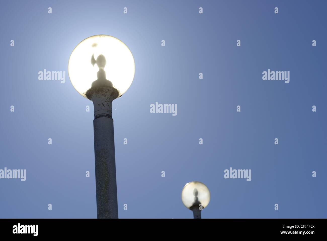lampade a forma di globo d'epoca fotografate contro il sole Foto Stock