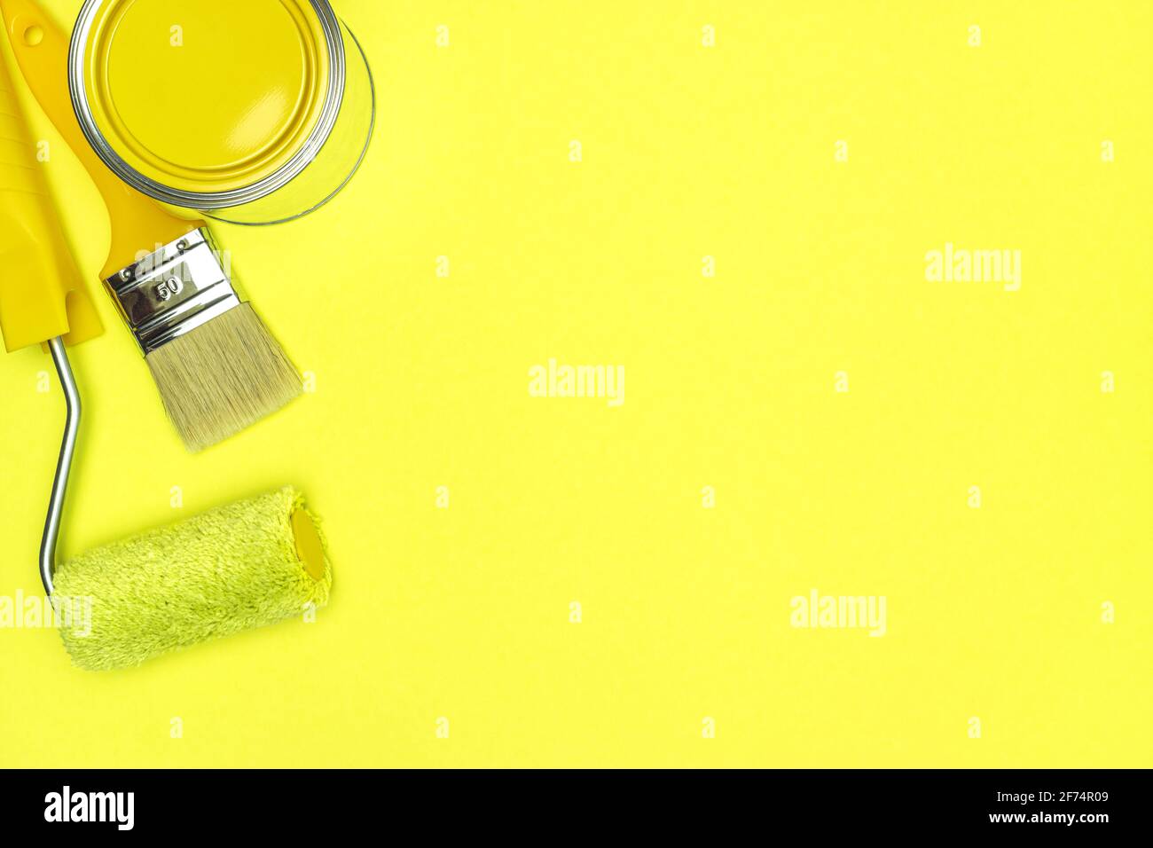 set di strumenti di pittura per il rinnovamento domestico su sfondo giallo. colori alla moda 2021. vista dall'alto. Foto Stock