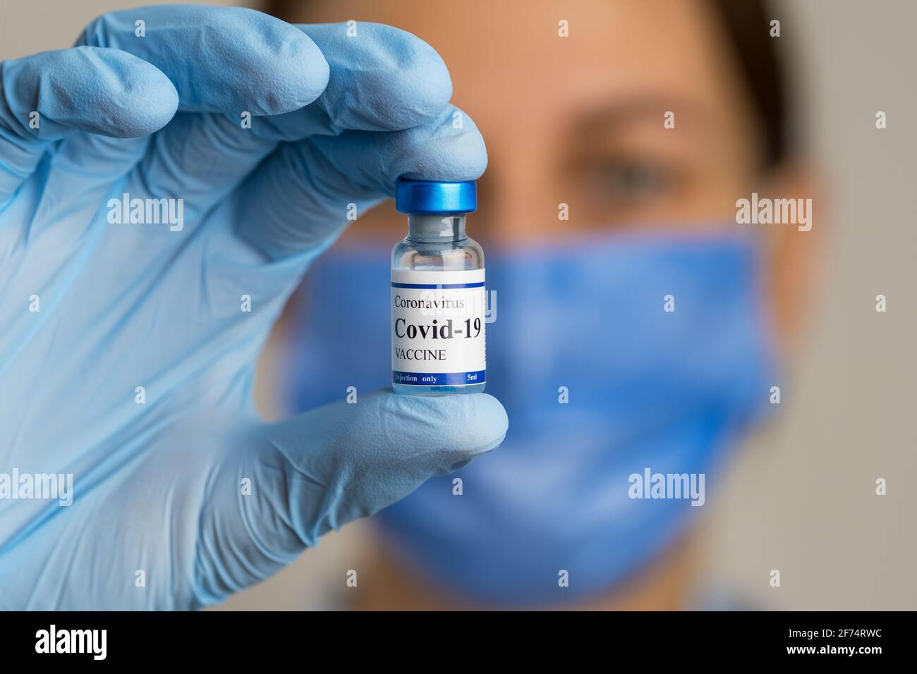 Il medico femminile contiene la siringa e il flaconcino di vaccino del coronavirus. Foto Stock