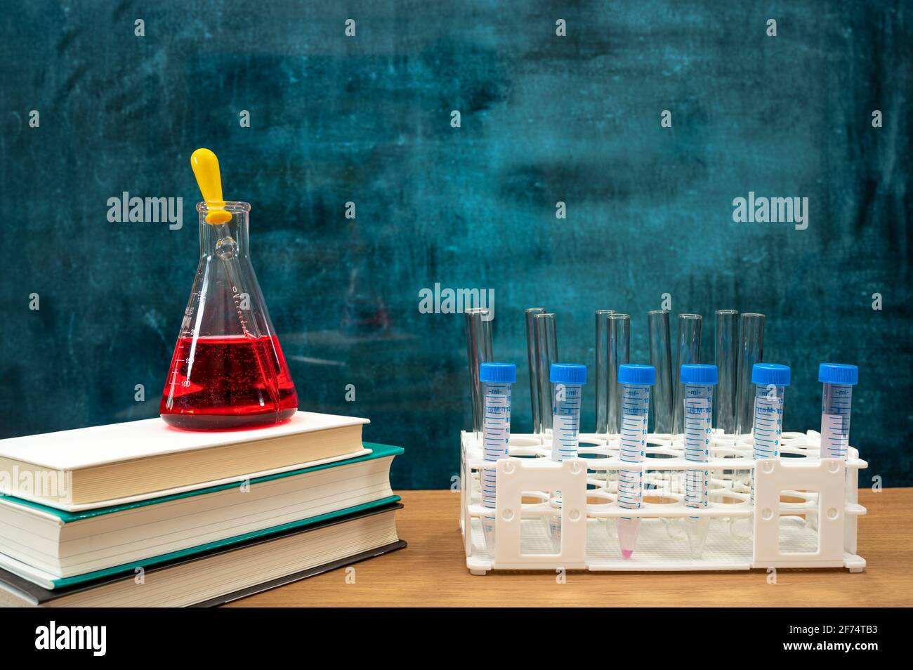 Libri e strumenti di sperimentazione scientifica sulla scrivania. Lavagna vuota. Concetto di istruzione. Foto Stock
