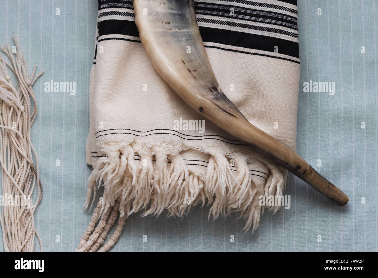 Una foto ravvicinata di uno shofar e di un tallit, su uno sfondo chiaro Foto Stock