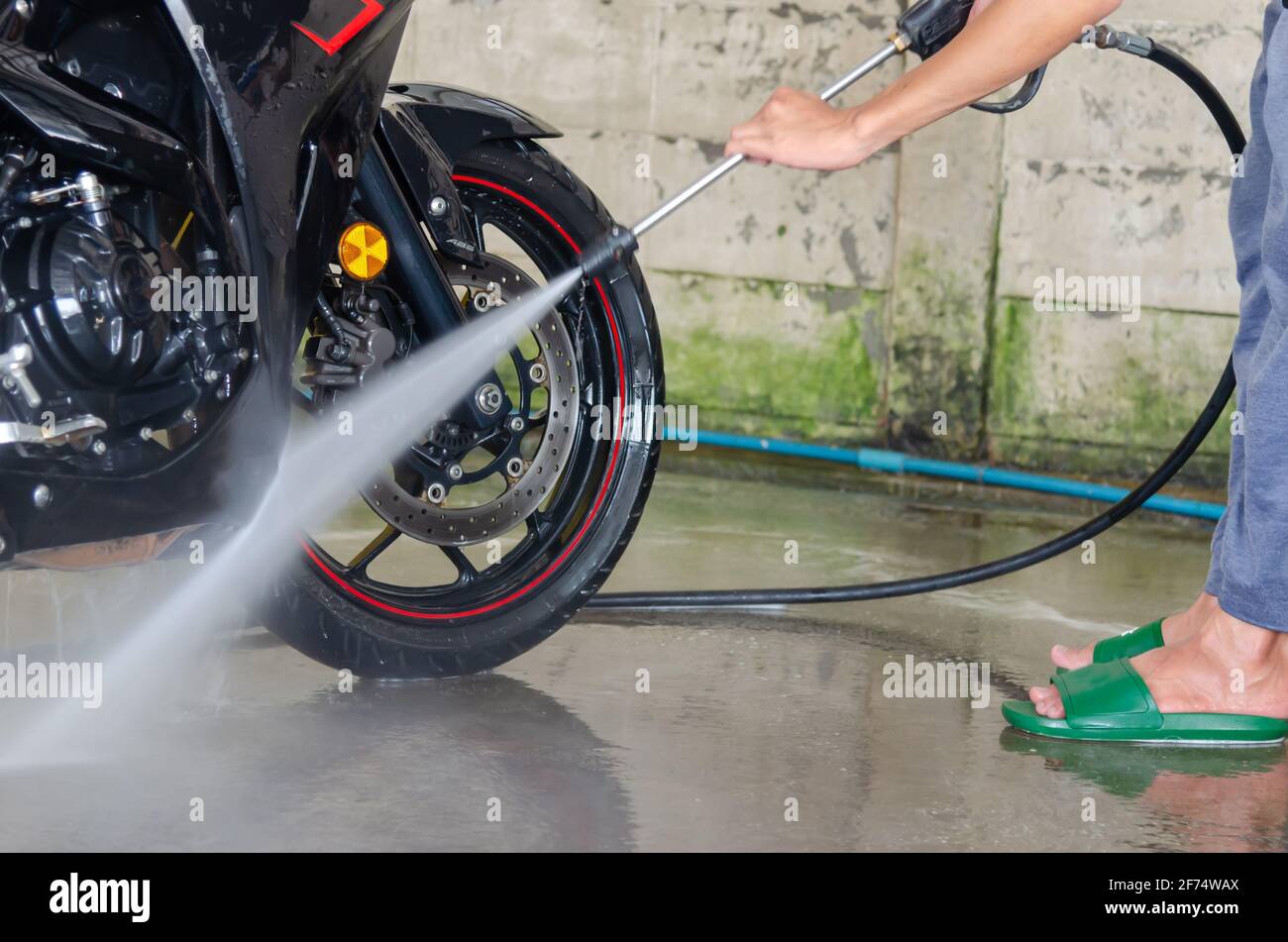 Pulire il lavaggio della motocicletta presso il negozio di autolavaggio Foto Stock