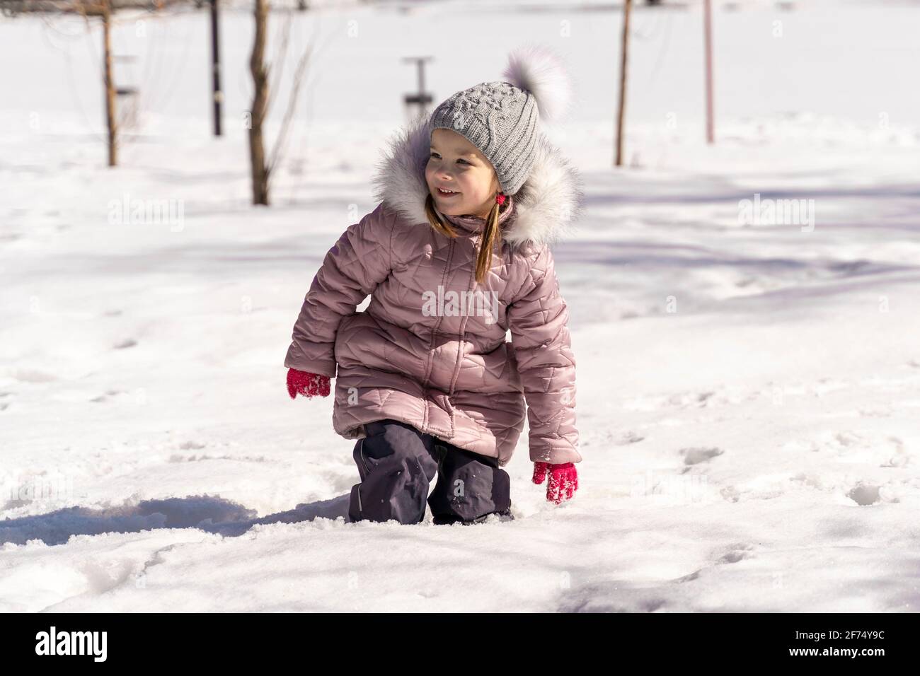 la bambina cadde in un ginocchio di neve-profondo. livello di neve grande Foto Stock