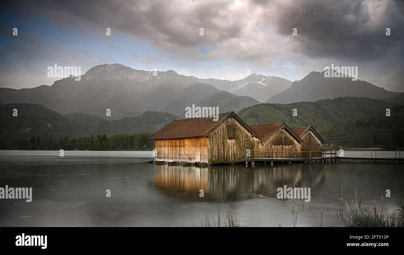 Capanne di pescatori in un tranquillo lago con montagne Foto Stock