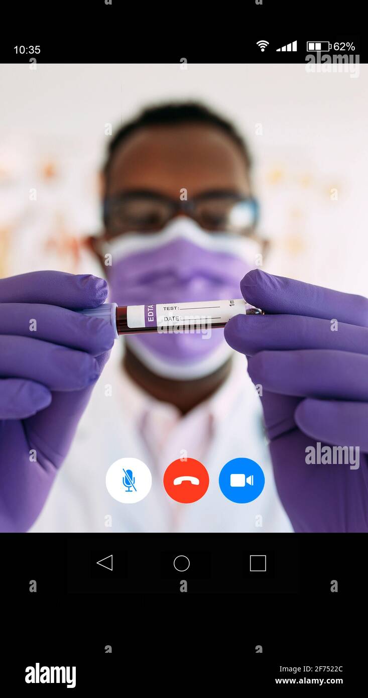 Da sotto contenuto portava imprenditore maschile in abbigliamento formale guardando via mentre si ha conversazione telefonica vicino moderno edificio a più piani su strada di Foto Stock