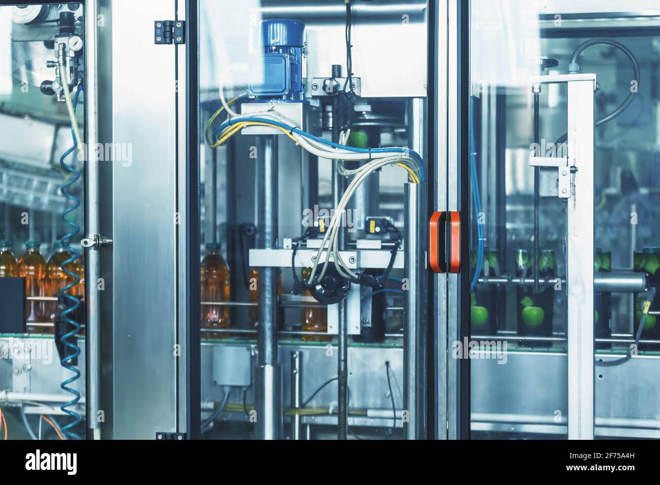 Macchina automatica per la preparazione di confezioni per bottiglie in plastica con bevande in fabbrica, produzione industriale di succhi e altre bevande. Foto Stock