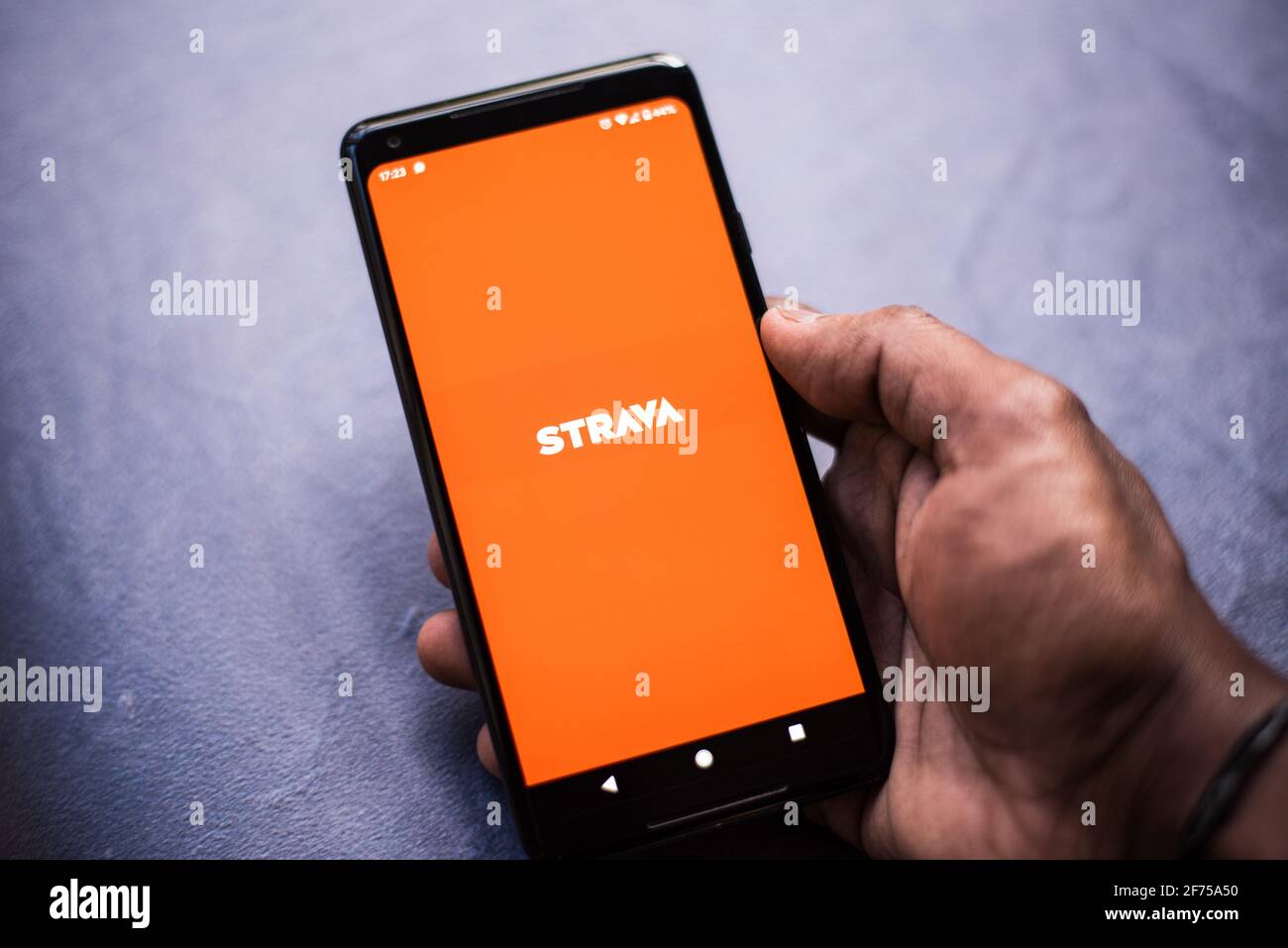 L'app GPS Strava Activity Tracking si apre sullo smartphone android da adulto maschio Foto Stock