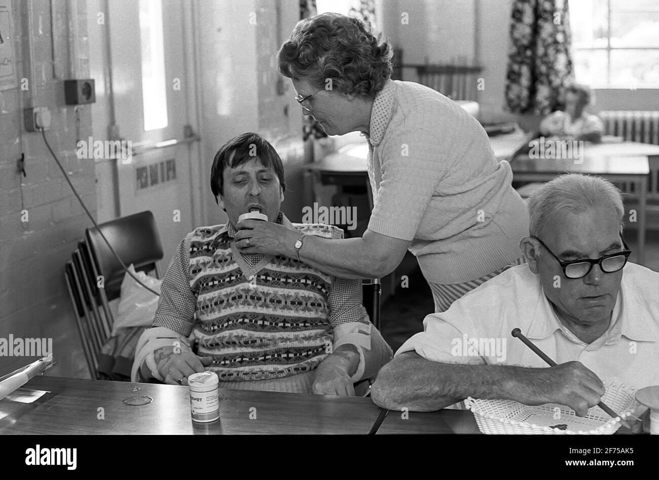 Strode Park un centro diurno per i fisici e mentali Handicap.Carer aiuta l'uomo con la bevanda Foto Stock