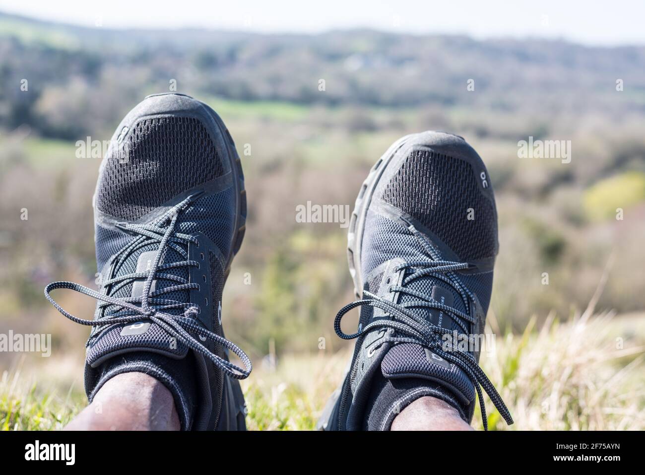 Scarpe in posizione di riposo su una collina con un vista sulla collina sullo sfondo Foto Stock