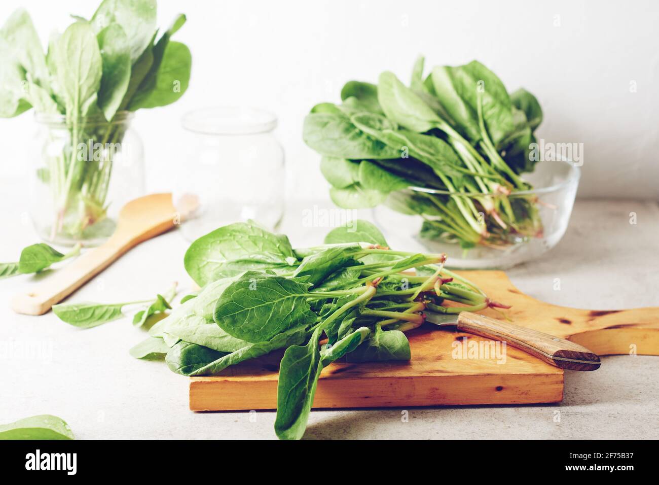 Foglie di spinaci verdi fresche su un tavolo da cucina. Foto Stock