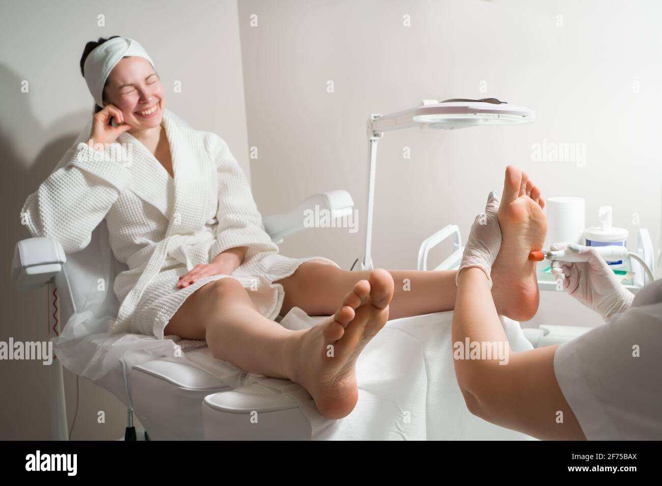 Medico di Podiatrist, esegue la procedura di trattamento delle gambe di una donna. Procedure cosmetiche dei piedi Foto Stock