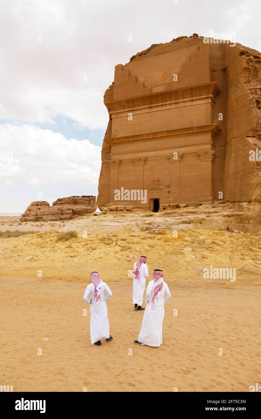 AlUla, Arabia Saudita, febbraio 19 2020: Tre sauditi stanno davanti alla tomba di Lihyan, figlio di Kuza, conosciuta come Qasr AlFarid, la tomba più iconica di A. Foto Stock