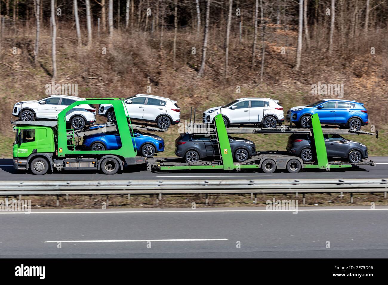 Adampol Scania autocarro per il trasporto di automobili caricato con nuove vetture Kia Sportage in autostrada. Foto Stock