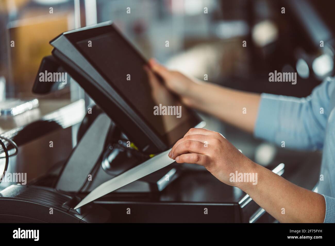 Processo di stampa della fattura per un cliente, processore di carte di credito, stampante per ricevute con bolletta della spesa cartacea e monitor touchscreen, POS Foto Stock