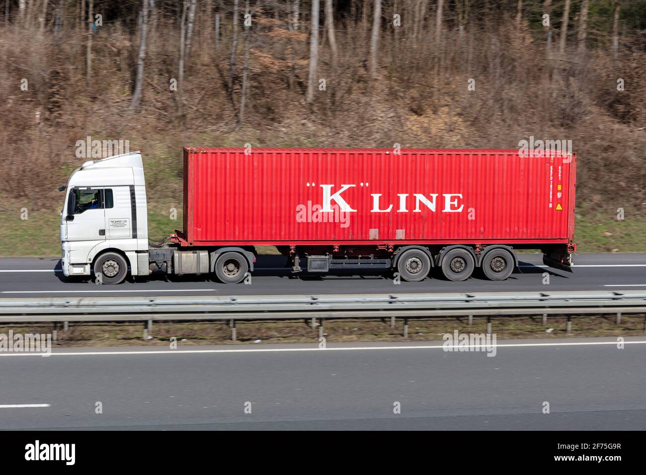 AUTOCARRO MAN a tre Sphed con container "K"Line in autostrada. Foto Stock