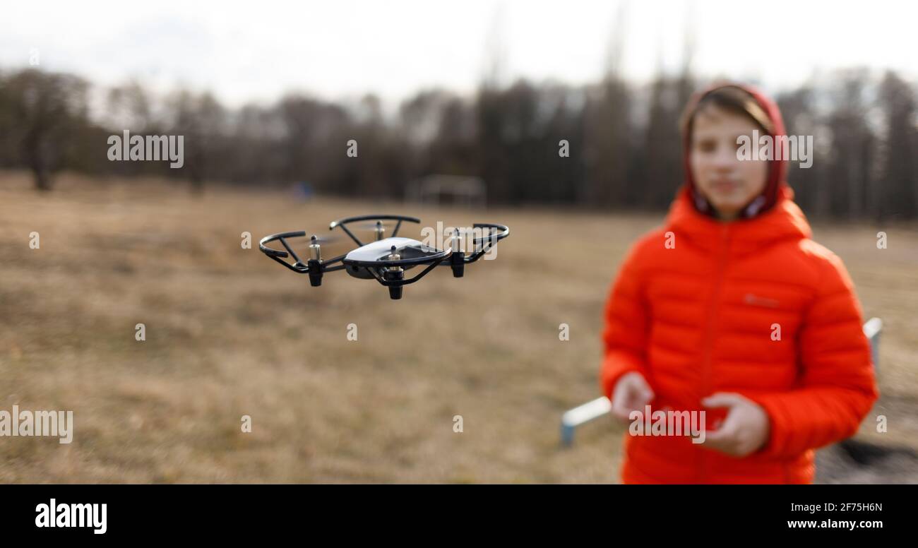 Ragazzo adolescente che vola piccolo drone nel parco Foto Stock