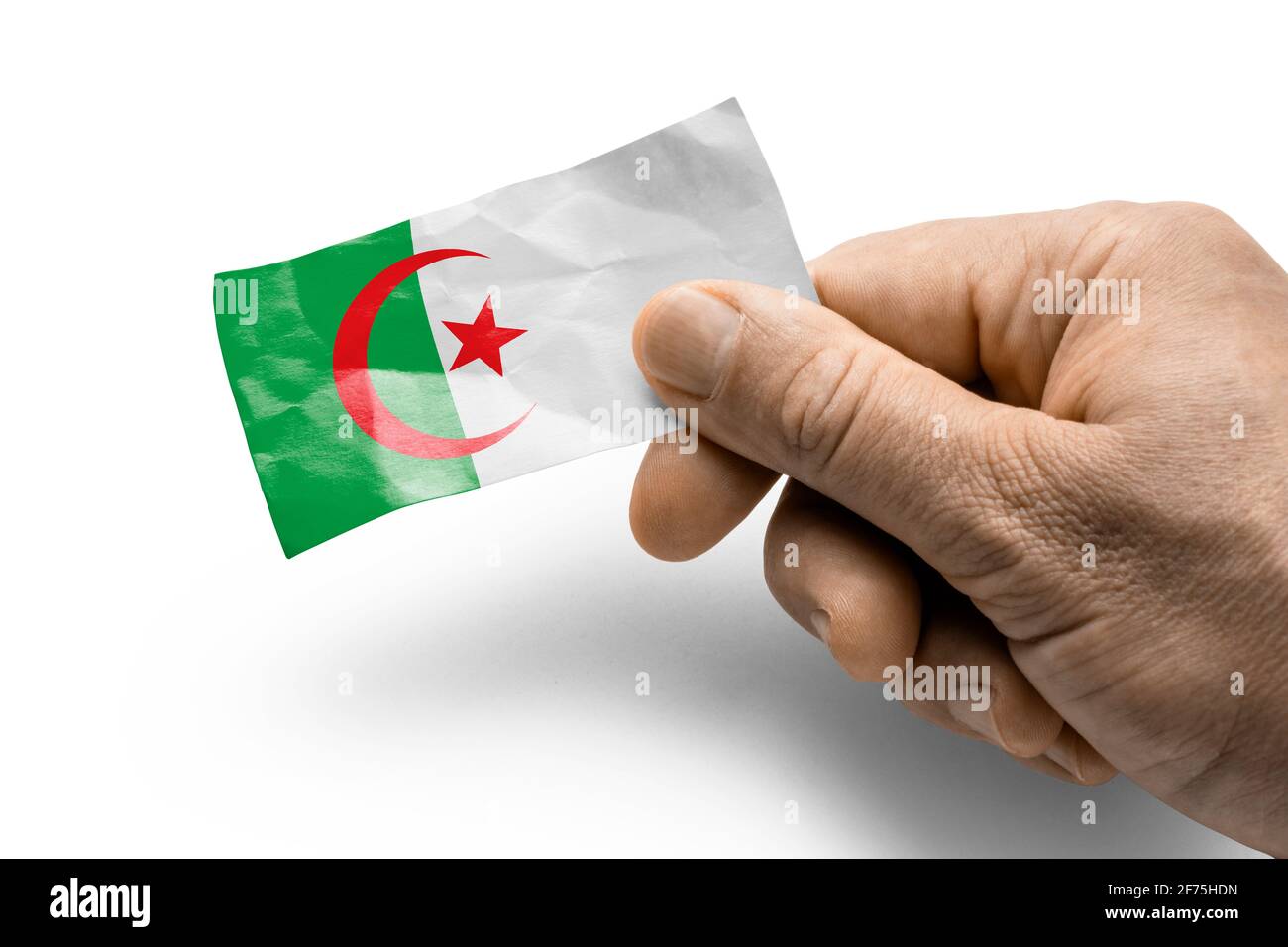 Mano che tiene una carta con una bandiera nazionale l'Algeria Foto Stock