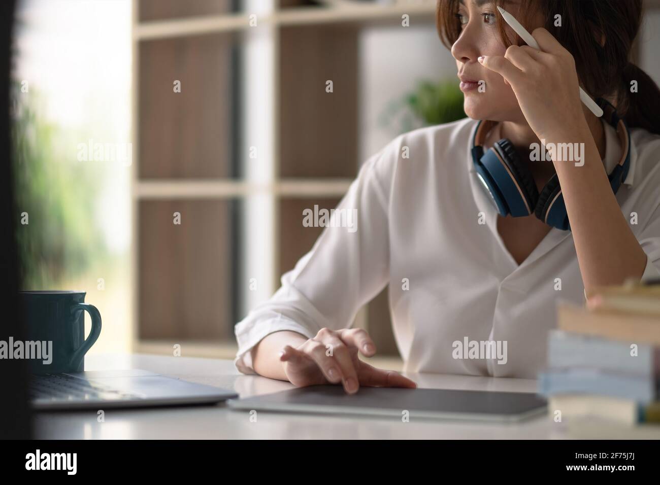 Immagine di un grafico che si disegna su un tablet digitale su legno tavolo da lavoro a casa Foto Stock