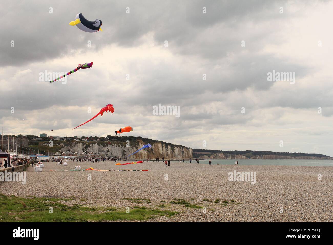 la costa di dieppe durante il festival internazionale di aquiloni con aquiloni colorati nel cielo nel mese di settembre in un giorno tempestoso Foto Stock