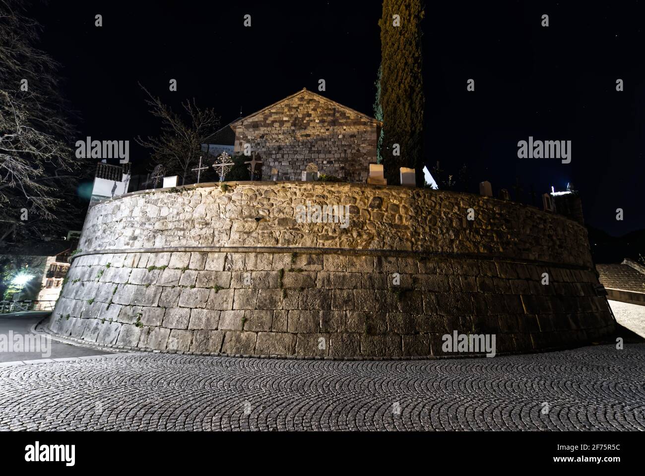 Un bellissimo scatto drammatico ad angolo basso di una chiesa cattolica cimitero nella notte. Tecnica di messa a fuoco selettiva. Foto Stock