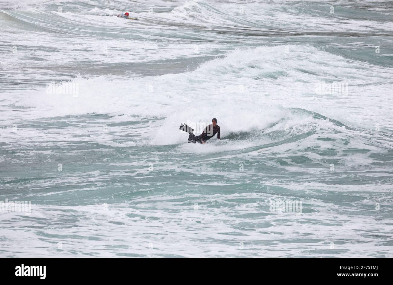 Porteath, Cornovaglia, 5 aprile 2021, ieri la gente era fuori godendo il sole glorioso sulla spiaggia, che cosa una differenza un giorno fa, come oggi il suo grigio e freddo con una spiaggia deserta in Portreath, Cornovaglia. Un surfer ha fatto il la maggior parte delle onde. L'alta previsione per oggi è 8C con una breeze.Credit fresca: Keith Larby/Alamy Live News Foto Stock