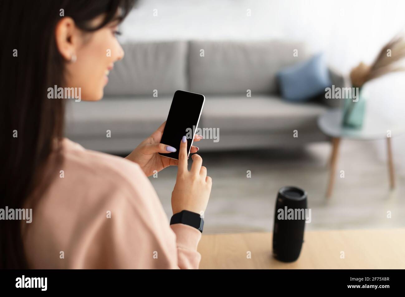 Vista posteriore della donna che usa il telefono con schermo di mockup vuoto Foto Stock