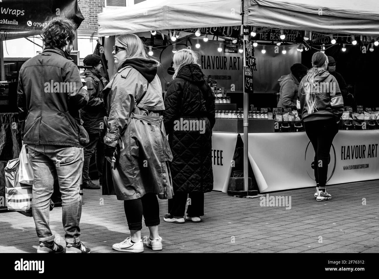 Epsom Surrey, Londra UK, 5 aprile 2021, UNA coppia giovane uomo e donna in piedi davanti ad una stall di mercato all'aperto Foto Stock