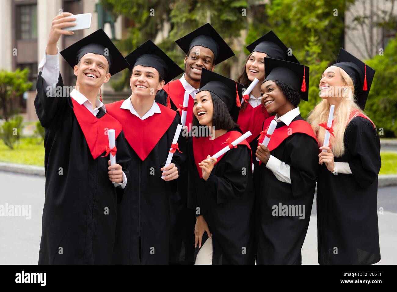 Gruppo multirazziale positivo di studenti che prendono selfie su smartphone Foto Stock